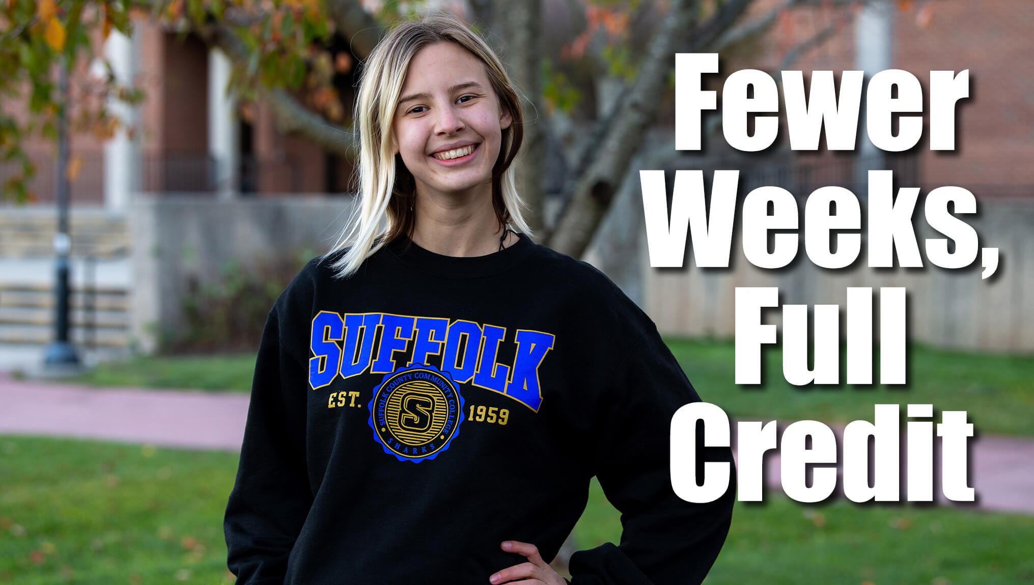 Few Weeks, Full Credit - A female student standing outside on campus wearing a Suffolk sweatshirt.