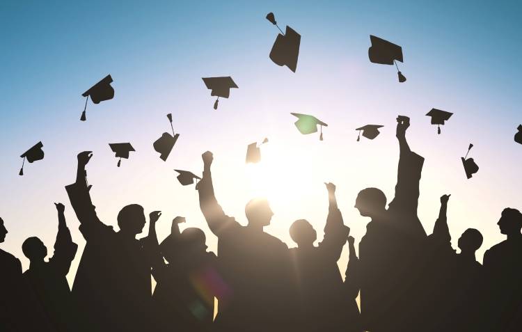 graduates throwing caps in air, silhouette